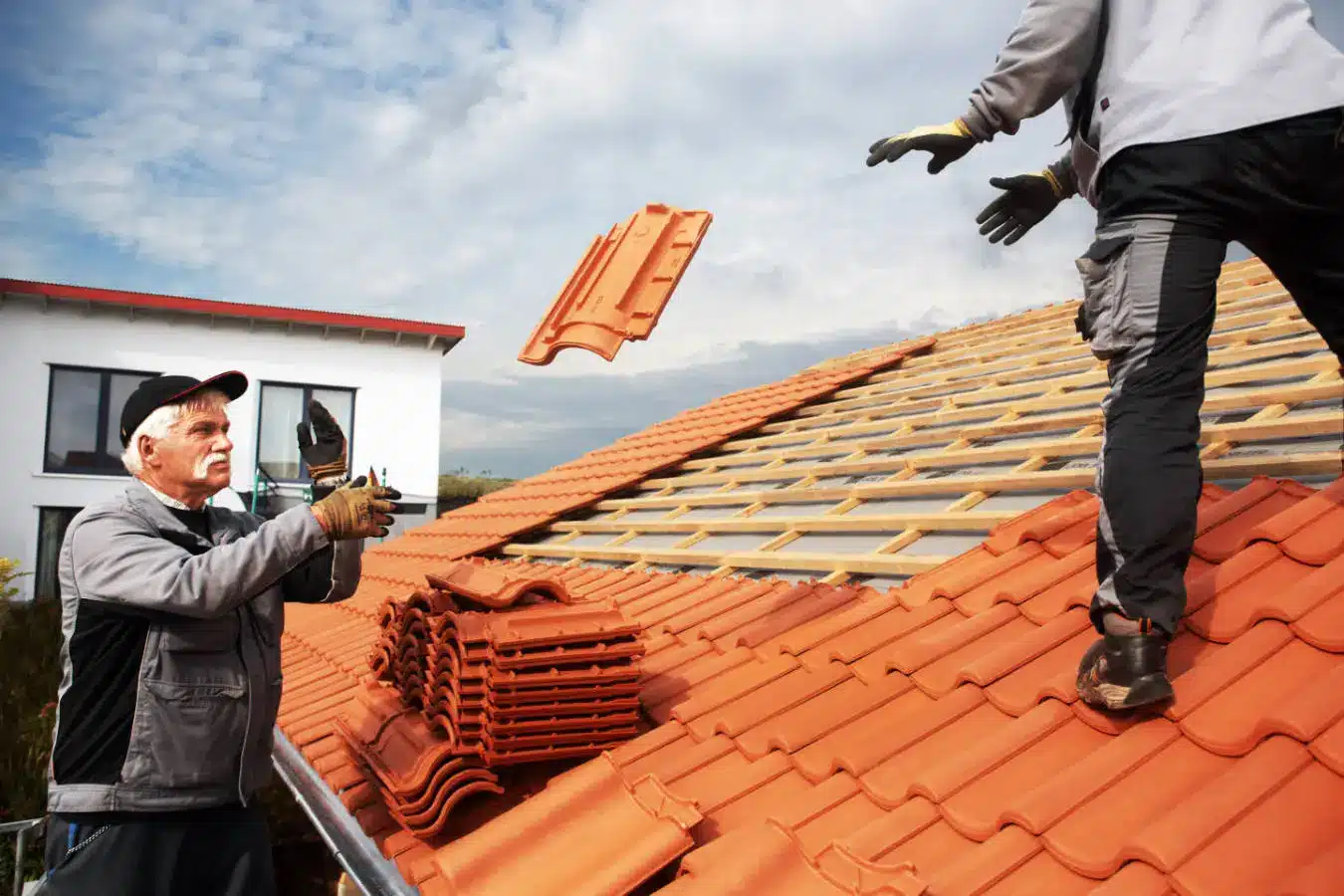 Vu sur deux ouvriers en train de poser des tuiles neuves dans le cadre d'un chantier de rénovation de toiture à Vernon dans leur avec Samuel Fortin